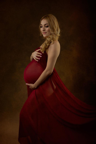 Expectant mother draped in red sheet