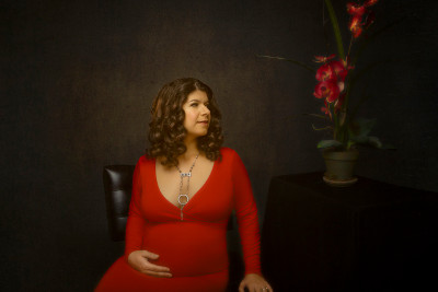 Maternity art portrait of woman in red dress